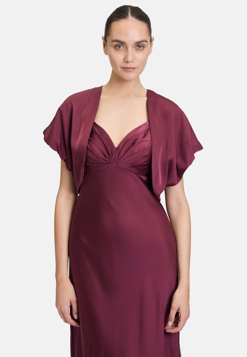 Bordeaux-farbenes Satin-Kleid mit tiefem Ausschnitt und gefälteltem Detail, begleitet von einem passenden, drapierten Schal. Glatte, elegante Textur.