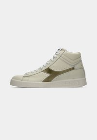 Baskets montantes en cuir de couleur crème avec un logo à accent doré. Présentent une surface texturée, un col rembourré et une semelle extérieure blanche.