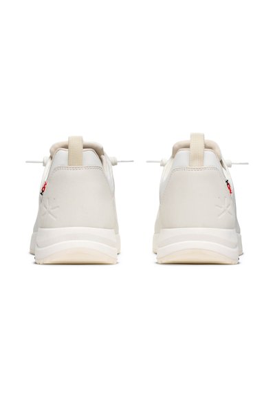 Bílé sportovní boty s hladkým matným povrchem, obsahující elastické tkaničky, měkkou patní tabulku a detail s logem na boku.