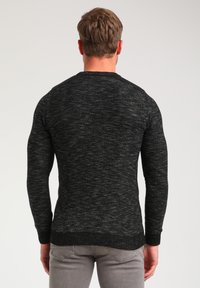 Black and gray knit sweater with a textured design, crew neckline, and ribbed cuffs. Features a fitted silhouette and solid color throughout.
