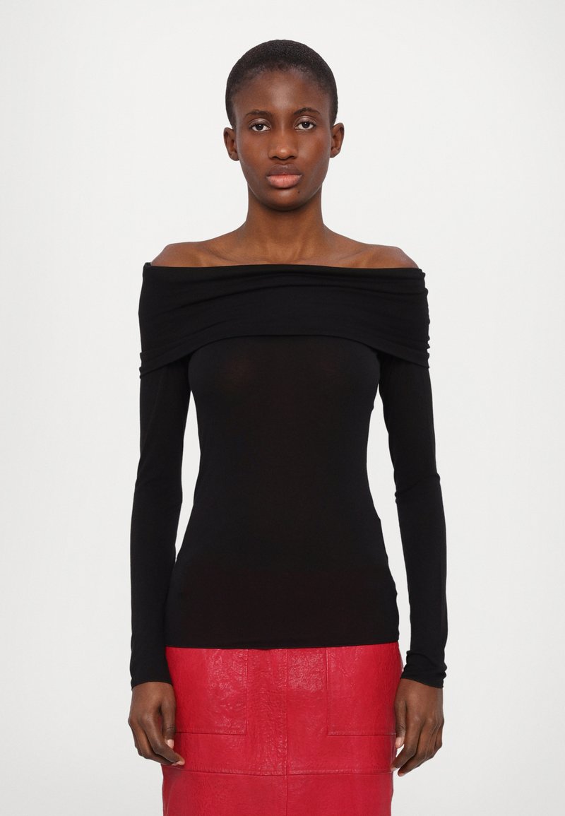 Zwarte off-the-shoulder top met lange mouwen en geplooid detail, gecombineerd met een gestructureerde, felrode rok. Gladde, aansluitende silhouet.