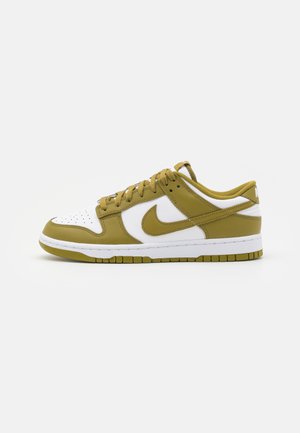 Sneakers Nike Dunk Low charakteryzują się zieloną i białą skórzaną cholewką, perforowanym noskiem, grubą białą podeszwą środkową oraz teksturowaną podeszwą gumową.