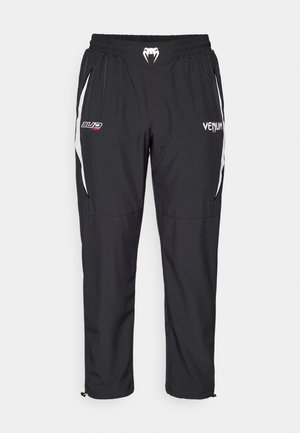 Zwarte sportieve broeken van lichtgewicht stof, met witte accenten, een elastische tailleband en zijzakken. Logo's zijn weergegeven.