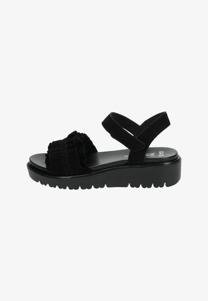 Black suede sandal with ruffled detailing, adjustable cross-strap, and a thick platform sole with a textured bottom for traction.
