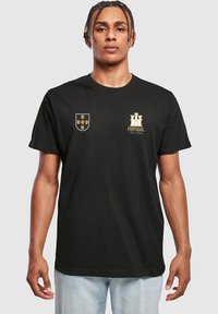 Sort kortærmet t-shirt med guld Portugal-våbenskjold og design på venstre bryst, lavet af blødt bomuldsstof.