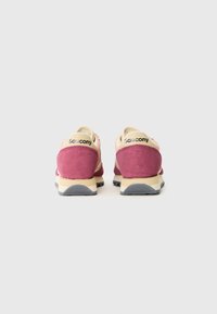 Et par rosa og beige Saucony sneakers vist fra baksiden mot en vanlig hvit bakgrunn.