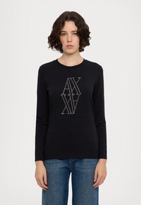 T-shirt a maniche lunghe nera con un design grafico in strass e la scritta "ARMANI EXCHANGE" sul fronte. Tessuto morbido e liscio, scollatura rotonda.