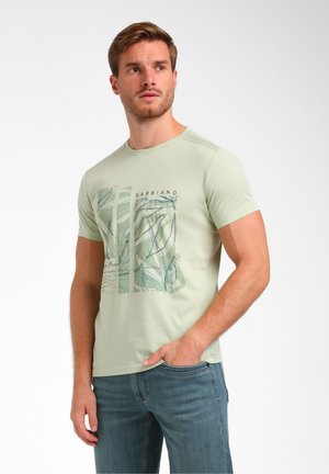 Light green short-sleeve t-shirt featuring a graphic print of leaves in blue and green tones, made from soft cotton material.