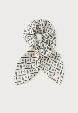 Chouchou en tissu blanc avec extrémités d'écharpe attachées, imprimé d'un motif de crosses et balles de lacrosse vert foncé.