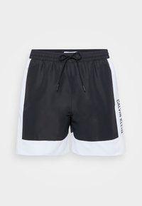 Črno-bele kopalne hlače z vrvico v pasu, stranskimi žepi in napisom 'Calvin Klein' na desni nogi. Gladek, lahek material.