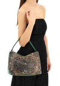 Borsa in pelle con manico verde, caratterizzata da un dettagliato motivo floreale a rilievo in oro e nero, forma arrotondata e hardware decorativo.