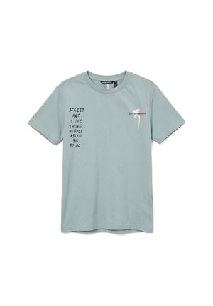 T-shirt azzurro chiaro a maniche corte con testo nero "STREET ART IS THE THING NOBODY ASKED YOU TO DO" e piccola macchia bianca di vernice con logo "ANTONY MORATO".