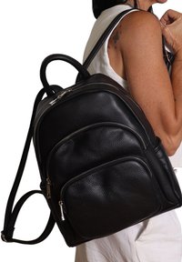 Zaino in pelle nera con diverse tasche con zip, manici arrotondati e spallacci regolabili. Superficie testurizzata con inserti in metallo lisci.
