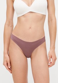 Mauve stof string met een gladde textuur en minimale bedekking. Kenmerkt zich door een naadloos ontwerp met lage zijkanten en een tailleband.