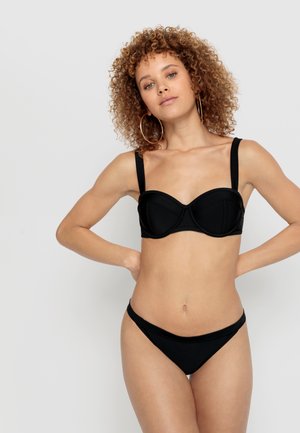 Conjunto de bikini negro que presenta una parte superior con aros estructurados y tirantes anchos, acompañado de una parte inferior de corte bajo. Textura suave y diseño minimalista.