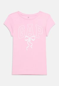 Ροζ μπλουζάκι για νήπια με κοντά μανίκια, με λευκό λογότυπο GAP και σχέδιο φιόγκου στο εμπρόσθιο μέρος, κατασκευασμένο από απαλό βαμβακερό ύφασμα.