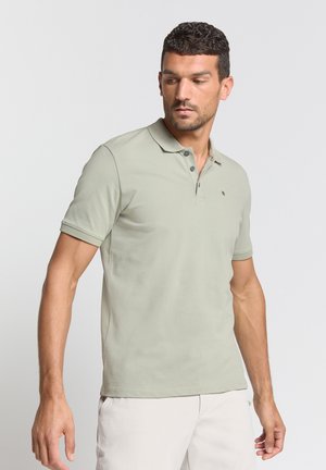Lichtgroene polo gemaakt van ademende stof. Beschikt over een klassieke kraag, drie knopen en korte mouwen. Minimalistisch logo weergegeven.
