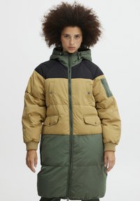 Polstret parka med en kombination af khaki, grønne og sorte paneler. Har hætte, forlommer og ribbede manchetter. Lynlås lukning.