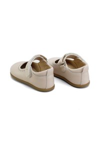 Zapatos Mary Jane de cuero rosa claro con una correa, diseño perforado, puntera redondeada y suela de goma. La parte trasera y los lados son lisos y resistentes.