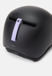 Μαύρο κράνος με ματ επιφάνεια, με ρυθμιζόμενο αερισμό σε λευκό και γκρι επένδυση στη βάση. Το όνομα της μάρκας "TAGGERT" είναι εμφανές στο πλάι.