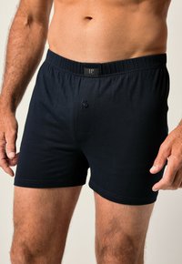 Boxer in cotone blu navy con cintura elastica, dotati di chiusura frontale con bottone e una superficie liscia. Senza fantasie né dettagli.
