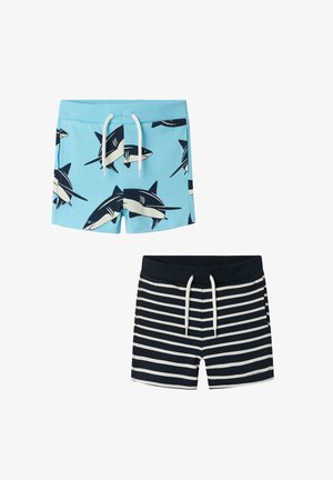 Blue swim shorts with shark print and white drawstring, paired with navy striped shorts featuring a matching drawstring.