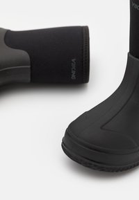 Botas negras impermeables con suela de goma texturizada y parte superior de neopreno. Presentan el logo "VIKING" en el lateral, diseñadas para la durabilidad y el confort.