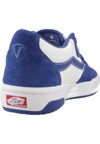 Zapatilla de ante azul y cuero blanco con forma redondeada, que presenta una franja blanca, amortiguación y un logo rojo en el talón.