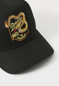 Casquette de baseball noire en coton avec un motif de serpent brodé et du texte. La casquette a une forme structurée et une visière incurvée.