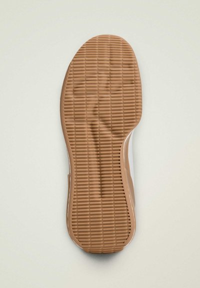 Shoe sole with a rubber base in light brown, featuring horizontal grooves for traction and a smooth edge transitioning to white material.