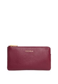 Portafoglio in pelle bordeaux con finitura texturizzata, chiusura con zip e logo del marchio in oro. Forma rettangolare slim con angoli arrotondati.