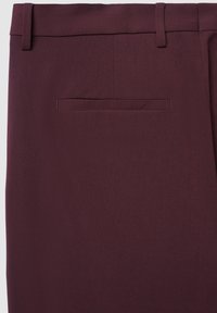 Vista posteriore di pantaloni su misura di un viola scuro, con una tasca a welt singola e passanti per cintura su uno sfondo neutro.