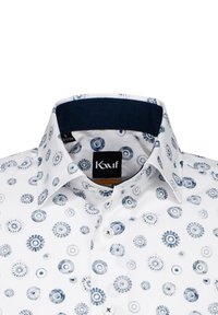 Weißes Hemd mit einem marineblauen Kragen, der ein Muster aus blauen kreisförmigen Designs aufweist. Fünf Knöpfe entlang der Vorderseite; Etikett im Kragen sichtbar.
