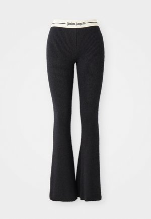Pantalons évasés en tricot côtelé noirs avec une taille crème portant le logo "Palm Angels" imprimé en noir. Tissu texturé avec une silhouette ajustée.
