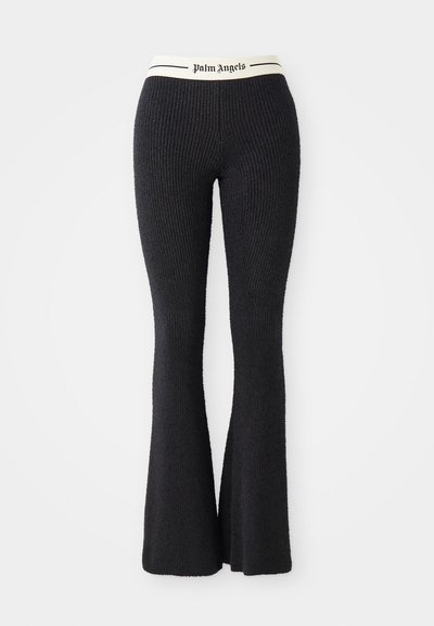 Pantalones de punto acampanados negros con una cintura crema que presenta el logo "Palm Angels" impreso en negro. Tejido texturizado con un silueta ajustada.