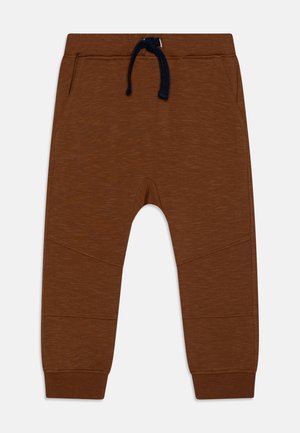 Pantalones marrones para niños pequeños con cordón de marino, cinturilla elástica, bolsillos laterales y tobillos ajustados sobre un fondo claro.