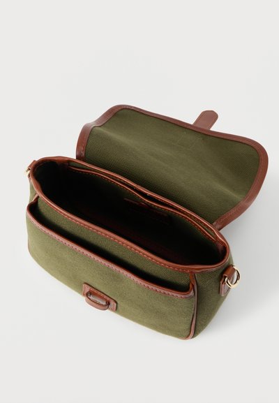 Χιαστί τσάντα από ελιά πράσινο ύφασμα με καφέ δερμάτινη επένδυση, ανοιχτό καπάκι και δύο εσωτερικά διαμερίσματα σε λευκό φόντο.