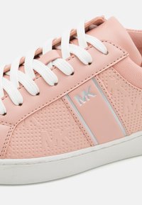 Rosa syntetisk lädersneaker med vita snören, texturerade sidor, silverdetaljer och en logotyp. Har en perforerad design och gummisula.