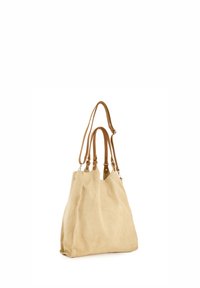 Sac fourre-tout en suédine beige avec des poignées en cuir. Forme décontractée, coutures visibles et accents métalliques. Design à ouvert sur le dessus pour un accès facile.