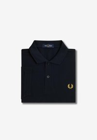 Polo shirt nera realizzata in tessuto testurizzato, con una chiusura a due bottoni e un piccolo logo a forma di corona d'alloro dorata sul lato sinistro del petto.