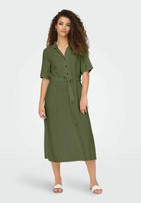 Olive green shirt dress made of lightweight fabric, featuring short sleeves, a button-down front, and a fabric belt at the waist.