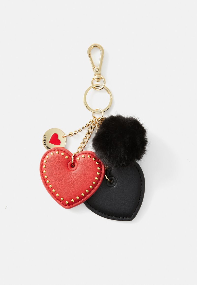 Red leather heart keychain with gold studs, paired with a black leather heart and a black fur pom-pom, attached to a gold clip.