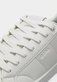 Λευκό δερμάτινο αθλητικό παπούτσι με χοντρά λευκά κορδόνια, λεπτομερή ραφή και ανάγλυφη επωνυμία "BORG" στο πλάι.