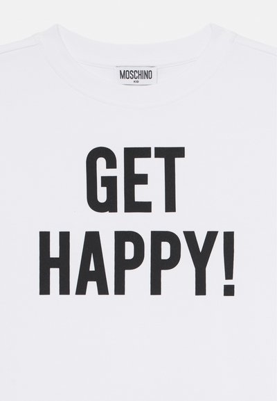 Bela bombažna majica s kratkimi rokavi, na kateri je v bold črnem besedilu napisano "GET HAPPY!". Oznaka na ovratniku pravi "MOSCHINO KID".