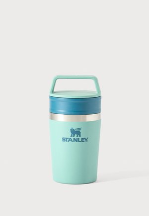 Gobelet de voyage Stanley vert menthe et bleu avec poignée et bande argentée, conçu pour transporter des boissons chaudes ou froides.