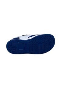 Baskets blanches avec semelle en caoutchouc bleue, présentant un motif texturé et une adhérence hexagonale, ainsi qu'un accent noir sur le côté.