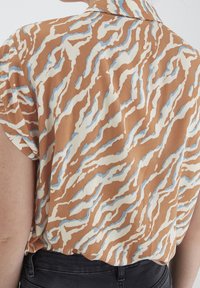 Kurzarmhemd mit einem braun- und cremefarbenen Wellenmuster und hellblauen Akzenten, aus glattem Stoff gefertigt und mit lockerer Passform.