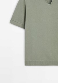 Pull tricot à manches courtes vert sauge avec encolure en V et bords côtelés aux manches et à l'ourlet, posé à plat sur un fond blanc.