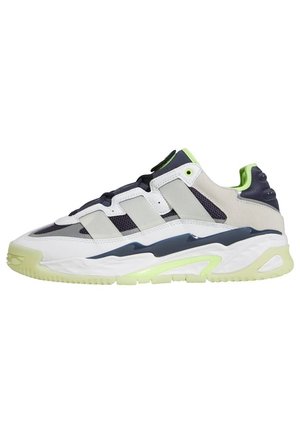 Lavtop-sneaker med hvide, grå, sorte og neon-grønne accenter, der har mesh og læderpaneler samt en chunky sål.