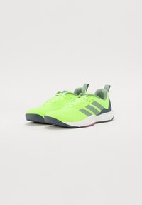 Neon green athletic sneakers with gray accents, mesh upper for breathability, and a sturdy rubber sole. Lace-up design with a tab at the heel.